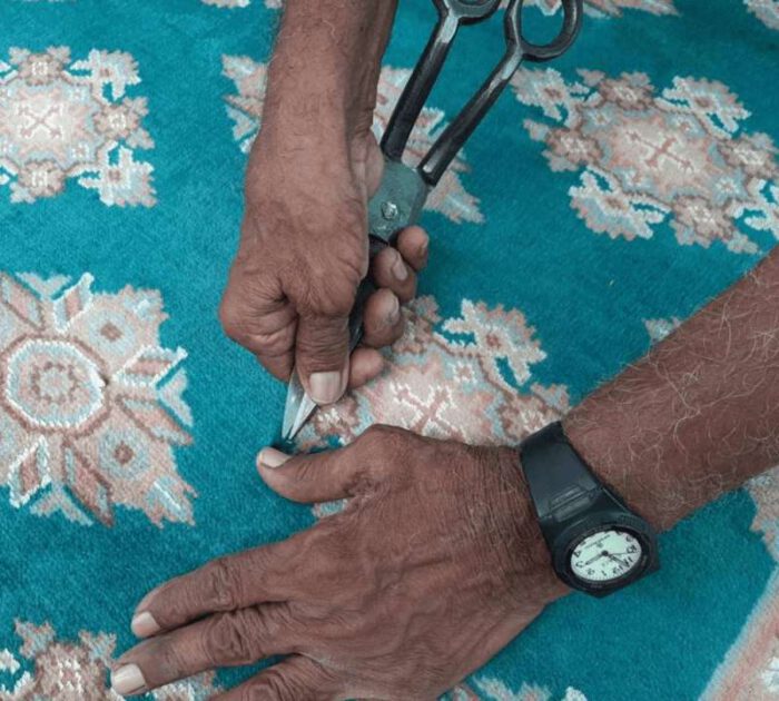 Ein blauer Teppich wir repariert. Teppich Reparieren.